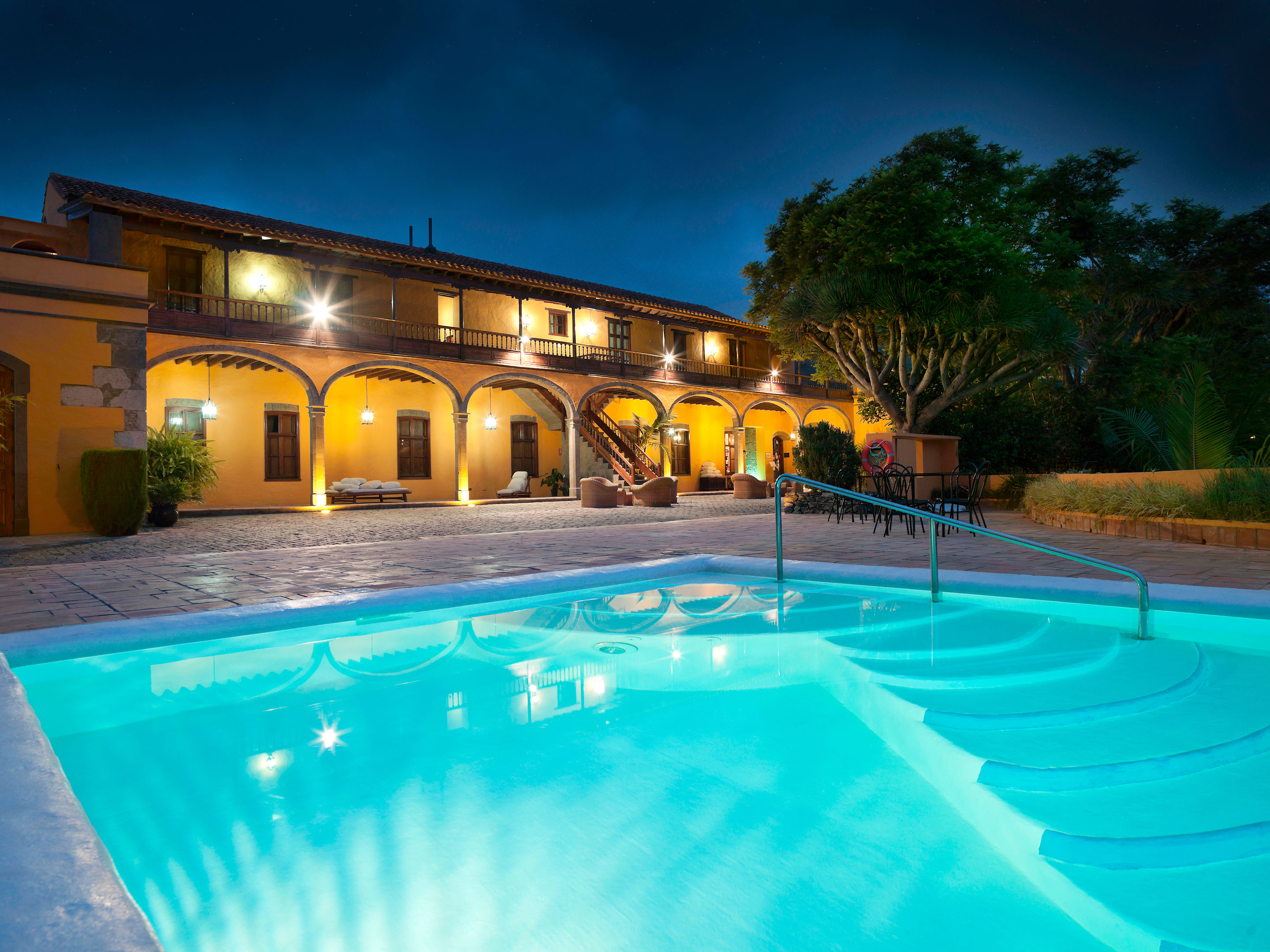 LiggingDit aantrekkelijke landhuis werd in koloniale stijl gebouwd en bevindt zich in een bananenplantage. Het is rustig gelegen en bevindt zich aan de dorpsrand van Arucas. Het stadscentrum met winkels en amusementsmogelijkheden bereikt u na ongeveer 4 km. Op ongeveer 1 km afstand bevinden zich bars en restaurants. Een halte van het openbaar vervoer vindt u op slechts enkele minuten loopafstand (ca. 100 meter). Het beroemde Kanteras-strand van Las Palmas bevindt zich op ongeveer 7 km afstand. HotelfaciliteitenHet hotel beschikt over een verwarmd buitenzwembad en zonneterrassen met ligstoelen