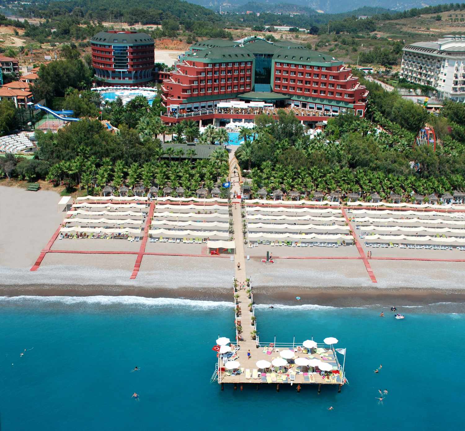 LiggingDit luxehotel ligt direct aan het eigen kiezelstrand. Het ongeveer 50.000 vierkante meter grote complex bevindt zich op ongeveer 30 km van Side en Alanya. Hiernaartoe rijdt een gratis shuttlebusservice. Voor het hotel bevindt zich een taxistandplaats en zijn er minibusverbindingen. De rijtijd van en naar de luchthaven Antalya is ongeveer 90 minuten. HotelfaciliteitenDe 416 kamers zijn verdeeld over 6 verdiepingen en zijn met een lift bereikbaar. Bij de 24-uurs receptie in de ontvangstruimte worden de gasten door meertalig personeel hartelijk begroet. In- en uitchecken uur kan 24 uur per dag. Het voorzieningenaanbod van het resort bevat een bagagedepot